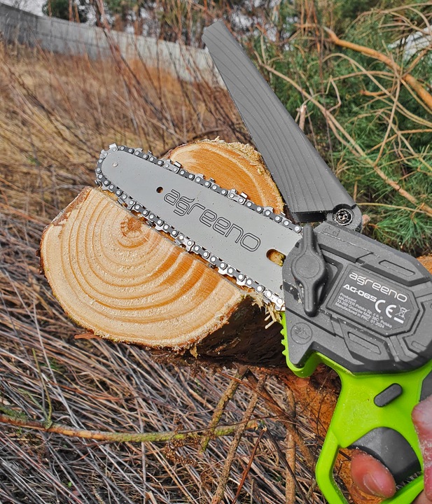 Akumulatorowa pilarka łańcuchowa marki Agreeno  w trakcie cięcia kawałka drewna - ujęcie nr 4